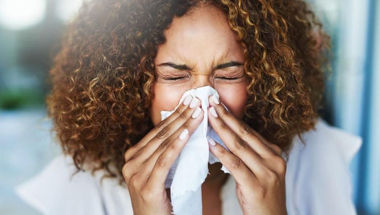 Mulher com alergia respiratória espirrando